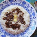 Rýžová kaše sypaná kakaem se sladidlem a s kouskem másla na talíři