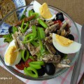 Salat z Nice naservírovaný v jídelní misce spolu s pečivem