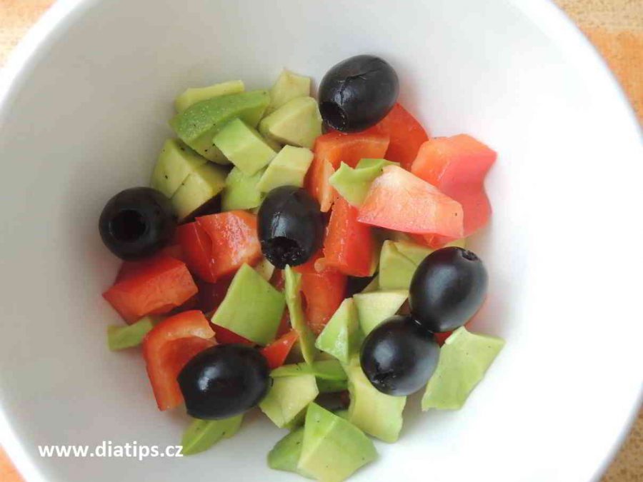 Lehký salát s avokádem a olivami v misce na stole